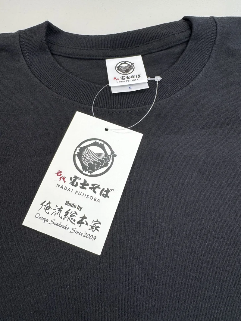ブランドタグと下げ札を取り付けた黒いTシャツの加工例
